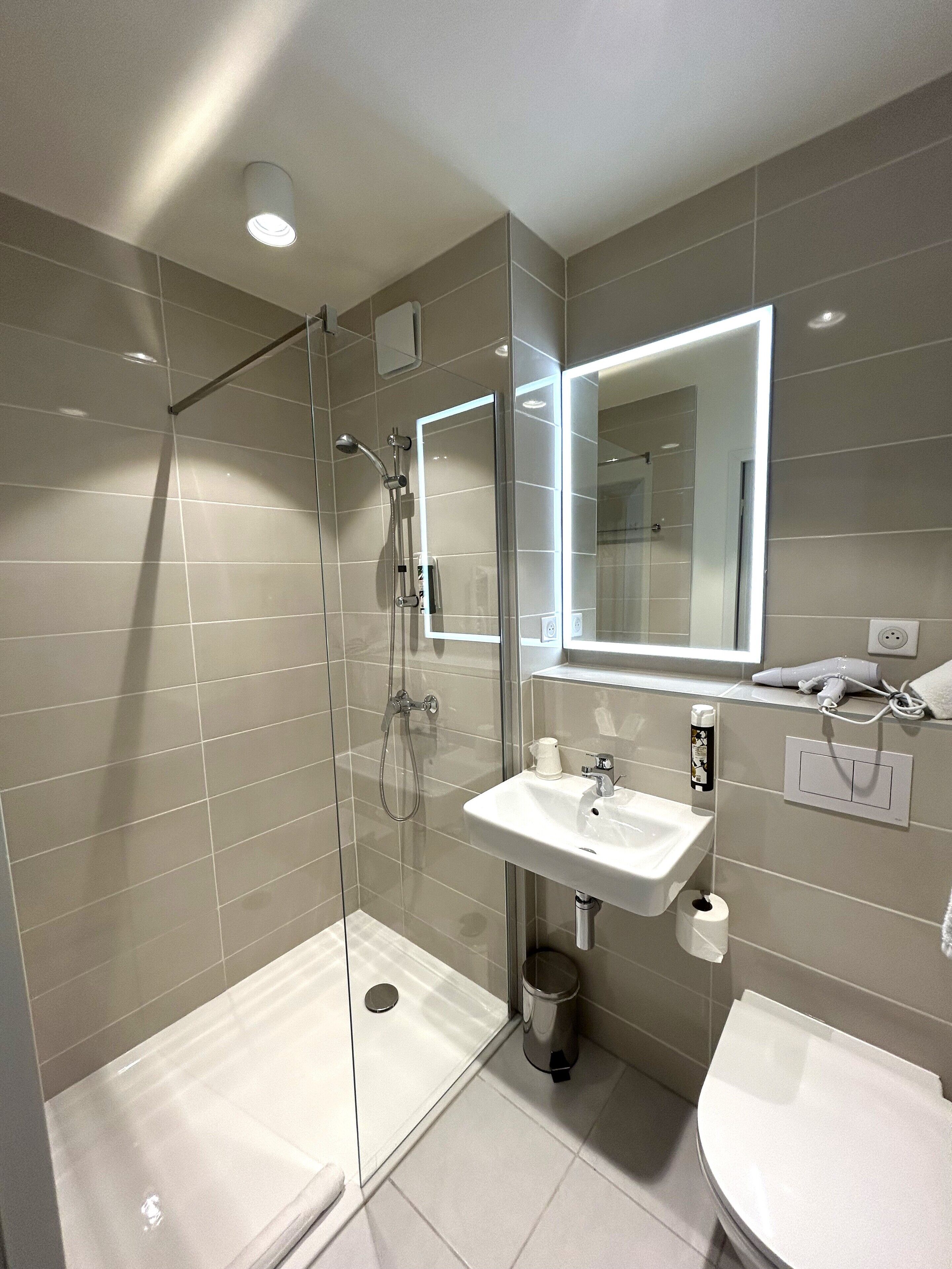 Tweepersoonskamer | Badkamer | Een douche, een haardroger, handdoeken