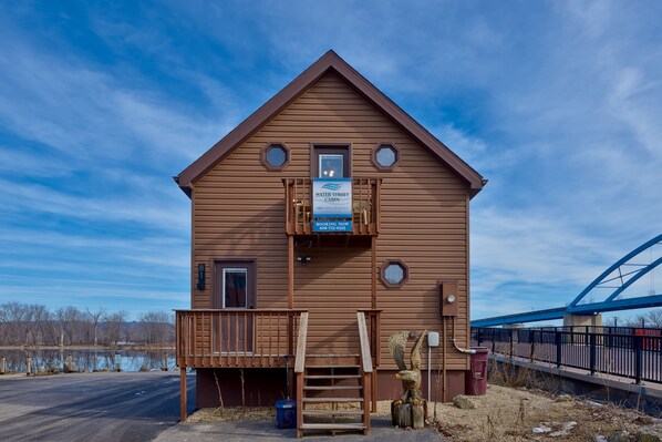 A cabin with a wooden exterior, a front porch, and a sign indicating it's a water street cabin.