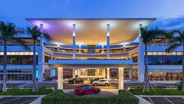 A multi-story hotel with a curved facade, multiple floors, and a covered entrance area. - Beachfront Remodeled Isla Verde (Carolina)