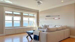 Un salón amplio con un gran ventanal, un sofá y una mesa de comedor.