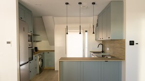 Een moderne keuken met lichtblauwe kastjes, een houten aanrechtblad en roestvrijstalen apparatuur.