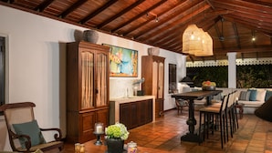 Un comedor acogedor con muebles de madera, una mesa con un florero y un cuadro en la pared.