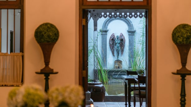 Un arco de entrada da a un patio con una fuente y zona de estar.