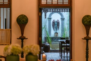 A doorway with an archway leading to a courtyard with a fountain and seating area. - Ceylo Villas (Induruwa)