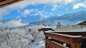 Ein verschneites Bergdorf mit Holzhäusern und schneebedeckten Bäumen.