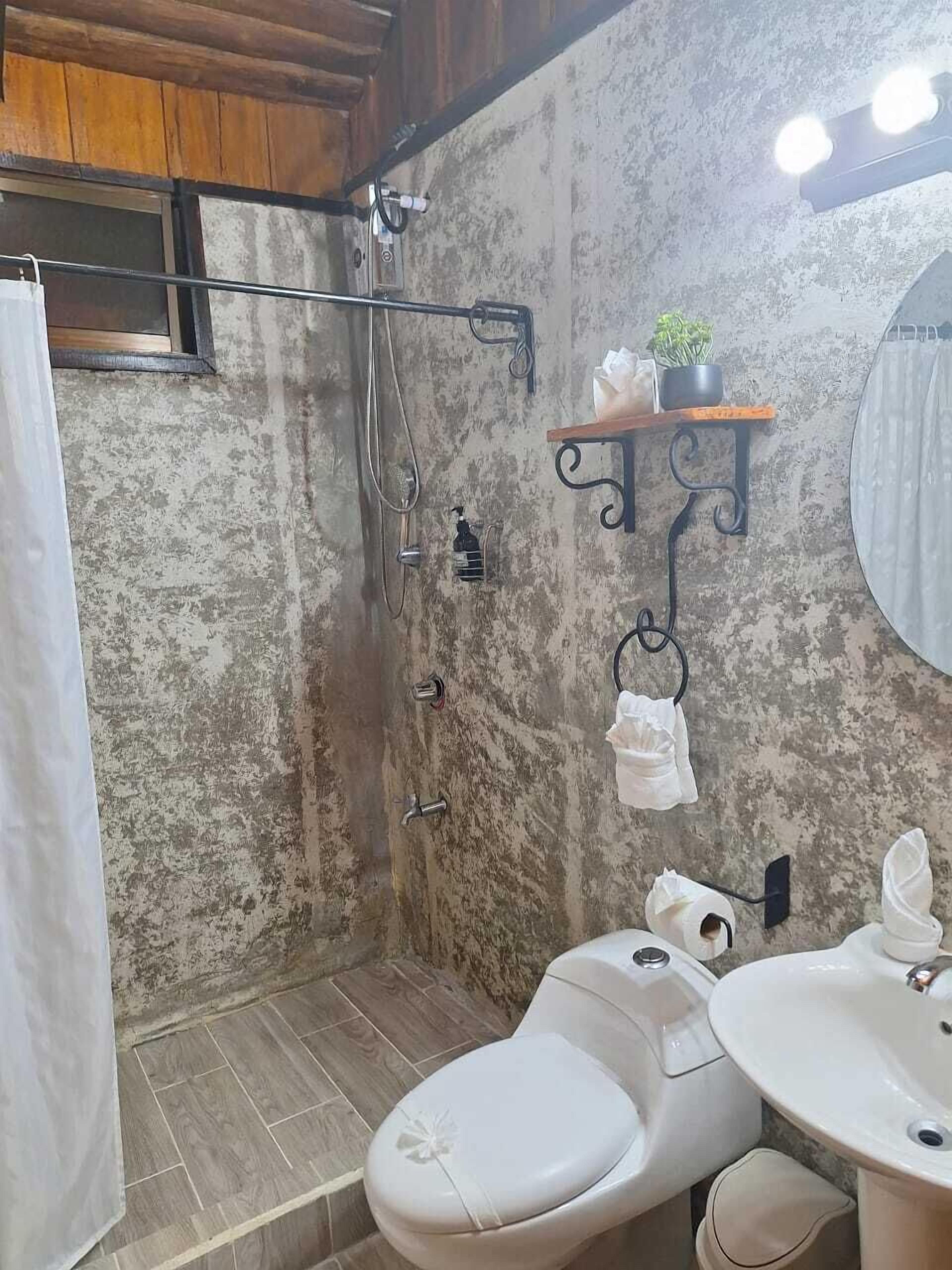 A bathroom with a shower, toilet, and sink.