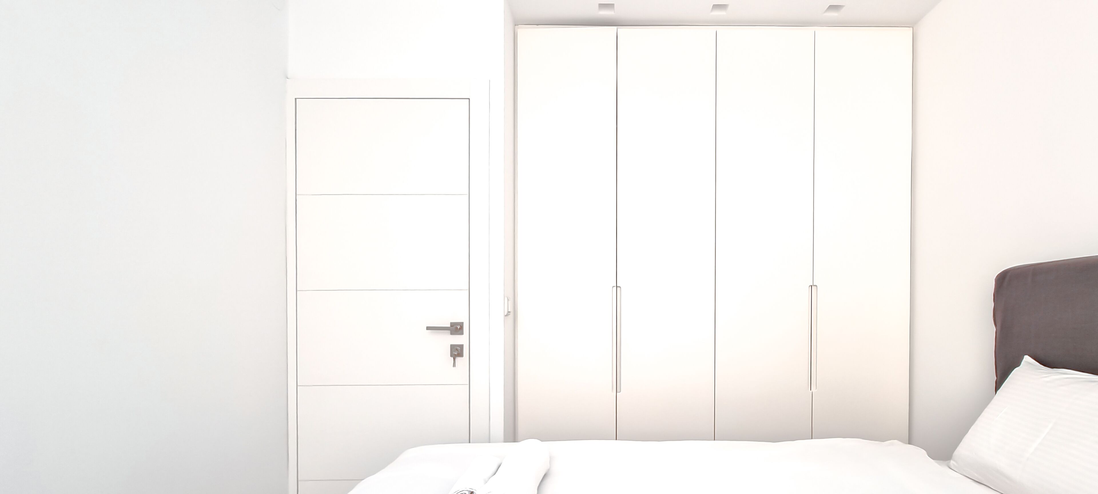 Ein Schlafzimmer mit einem Bett, einem Kleiderschrank und einem Nachttisch.