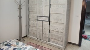 Un dormitorio con armario, cama y espejo.