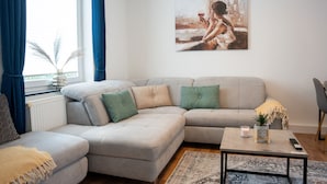 Uma sala de estar moderna com um sofá seccional, uma mesa de centro e um quadro na parede.