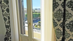 Une pièce dotée d’une grande fenêtre, de rideaux et offrant une vue sur le paysage urbain.