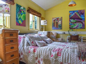 A bedroom with a bed, dresser, and artwork on the walls.