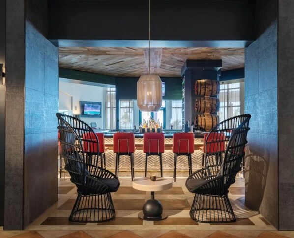 A modern bar area with black wireframe chairs, a round table, and a wooden ceiling. - Beachfront Boutique Villa @ Wyndham Rio Mar Resort (Mameyes II)