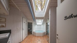 A bathroom with a skylight, a bathtub, and a door labeled 'Bathroom.' - Ferienhaus Ostseele mit Whirlpool, Dampf- und Normale Sauna Sowie Kamin (Brodersby)