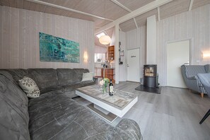 A modern living room with a sectional sofa, a coffee table, and a fireplace.