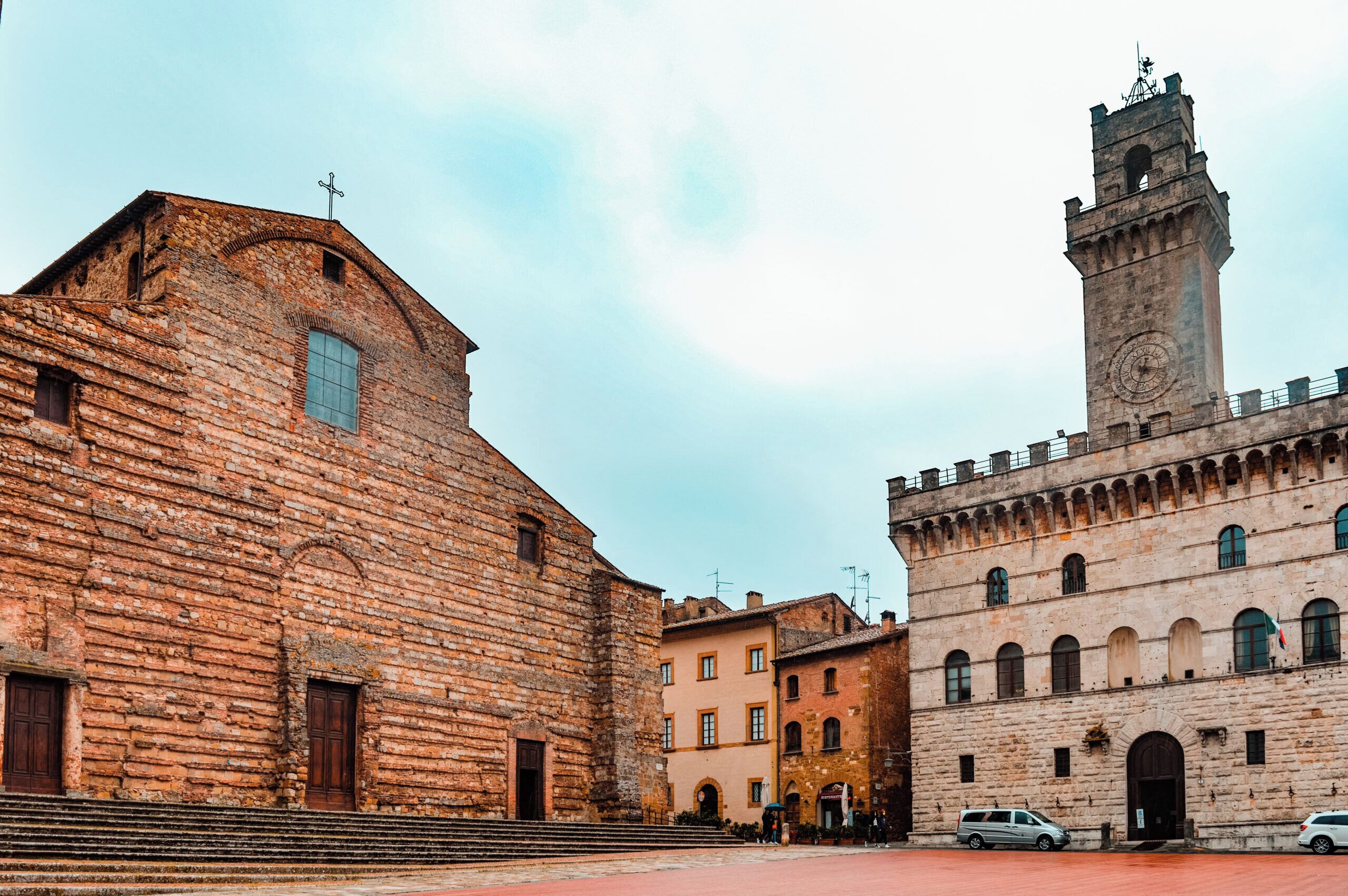 A historic building with a prominent tower and a large arched doorway.