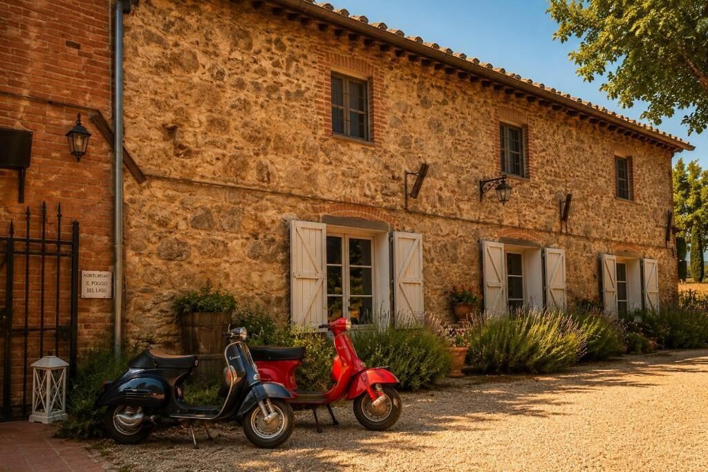 Un bâtiment en pierre à l’aspect rustique, avec une allée pavée et deux scooters garés devant.