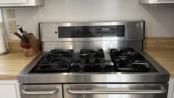 Een microgolfoven, een oven, een kookplaat, kookgerei, borden en bestek