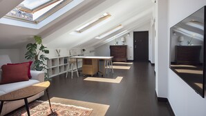 Ett modernt rum i loftstil med takfönster, en matplats och ett kök.