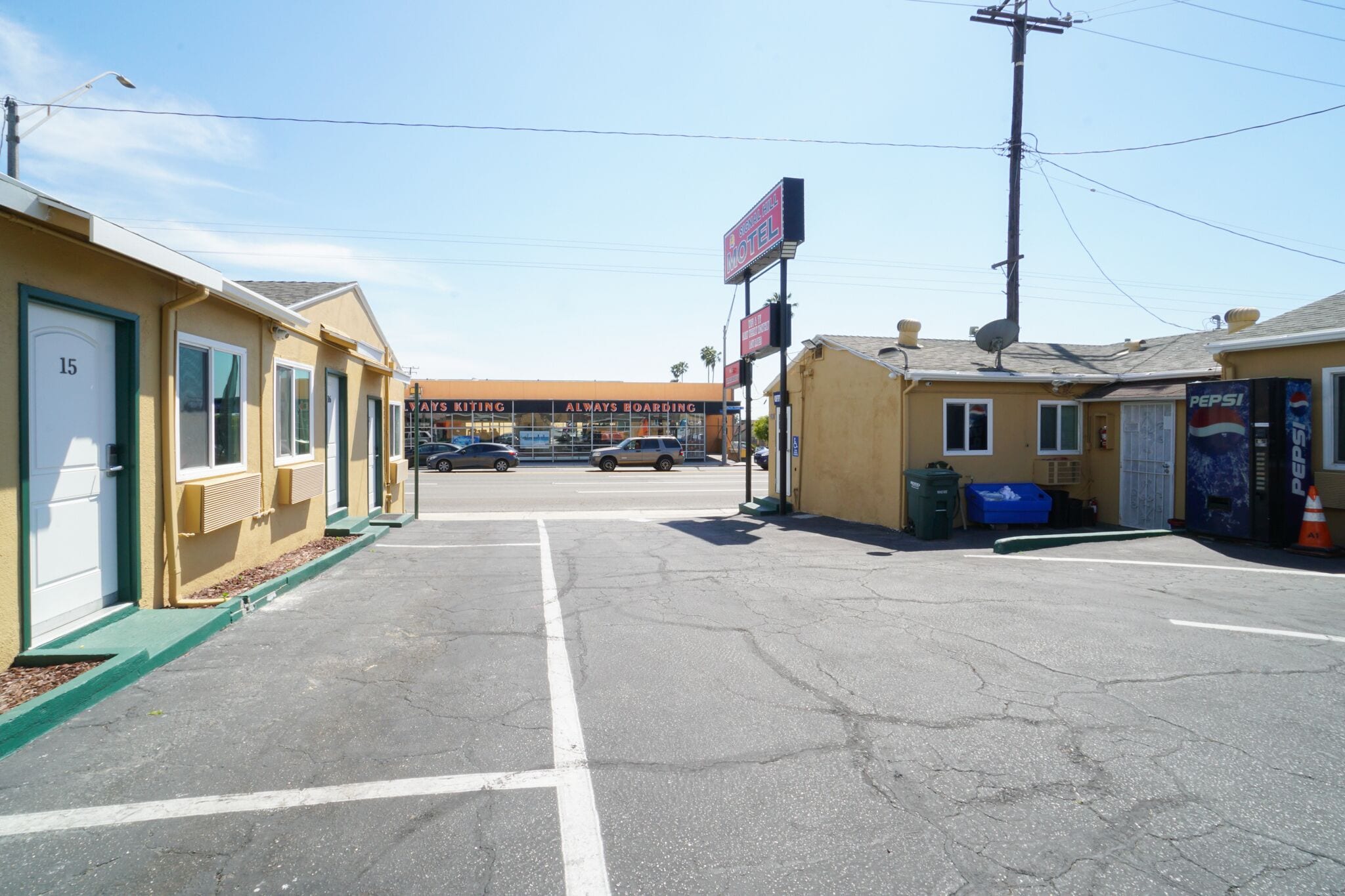 A motel with a parking lot, a visible building number '15', and a sign for 'Pepsi'.