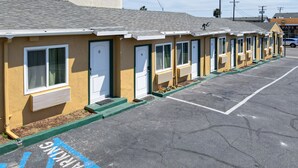 A row of single-story motel rooms with individual doors, numbered from 8 to 11, and a parking area with marked spaces.