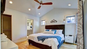 A bedroom with a bed, a nightstand, a ceiling fan, a window, and a wardrobe.