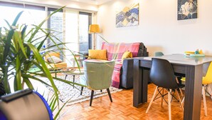 Ein modernes Wohnzimmer mit Essbereich, großen Fenstern und Blick ins Freie.
