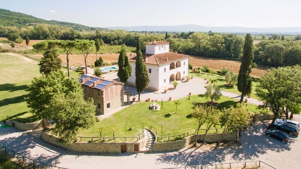 A villa with a courtyard, stone walls, and a swimming pool.