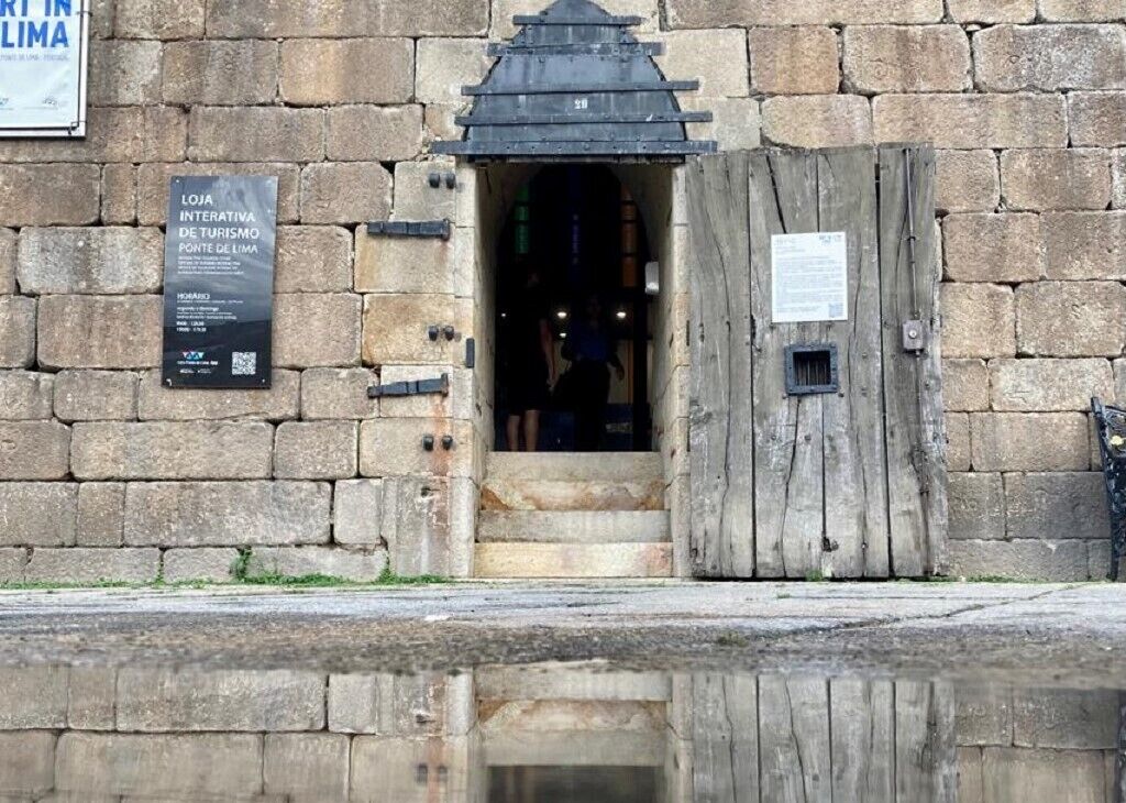 A stone building with a wooden door and steps leading to an entrance.