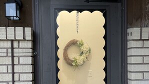 A black door with a beige decorative panel, a wreath, and a number '2' above it. - Brighten Your Day Getaway (Rexburg)