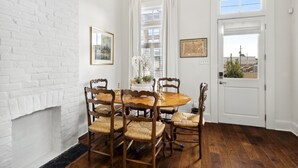 A dining room with a brick wall, a white door, and a window with a view of buildings.