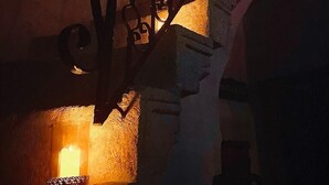 A staircase with ornate metal railings and a lit candle at the bottom. - Yohannes Stone Cappadocia (Ürgüp)