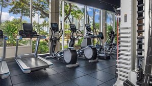 Une salle de sport équipée de tapis de course, de vélos elliptiques et de matériel de musculation.