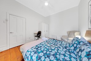 A bedroom with a bed, a desk, a chair, and a wardrobe. - A Beautiful Terrace House With Parking & Courtyard (North Melbourne)