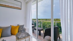 A balcony with a view of greenery and a distant landscape.
