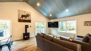 A cozy living room with a sofa, a fireplace, and a television.