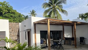 Une terrasse extérieure moderne avec une piscine, un mur en pierre et des palmiers.
