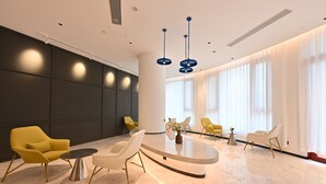 A modern hotel lobby with a central seating area, large windows, and a minimalist design. - Changsheng Hotel  (Jiangmen)