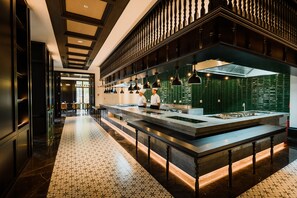Une cuisine moderne dotée d’un îlot central, de barrières noires et d’un sol à motifs.