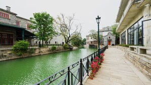 Un canal bordé de bâtiments en pierre de chaque côté, une rambarde métallique et un lampadaire.