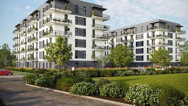 Ein modernes, mehrgeschossiges Wohngebäude mit Balkonen, einem angelegten Garten und blauem Himmel.