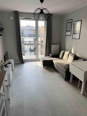 Relax in this stylish living room with a balcony offering views of the surrounding buildings.