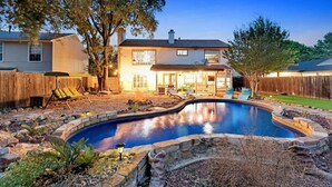 A backyard with a swimming pool, a wooden fence, and a house. - 5 BR w/pool, minutes to Six flags, AT&T stadium (Grand Prairie)