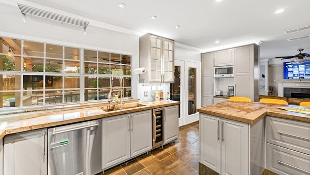 A modern kitchen with a large island, stainless steel appliances, and a view of the outdoors. - 5 BR w/pool, minutes to Six flags, AT&T stadium (Grand Prairie)