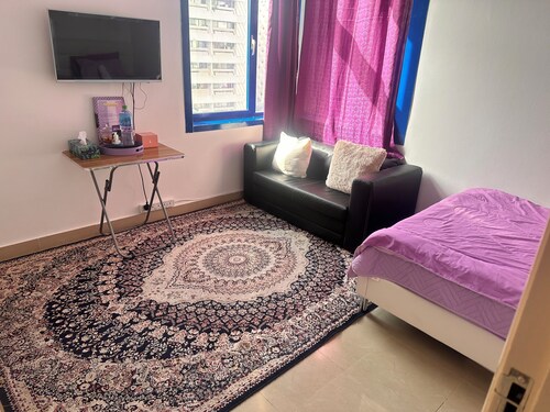 a charming and cozy purple themed room within the heart of the city .