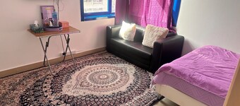 a charming and cozy purple themed room within the heart of the city .