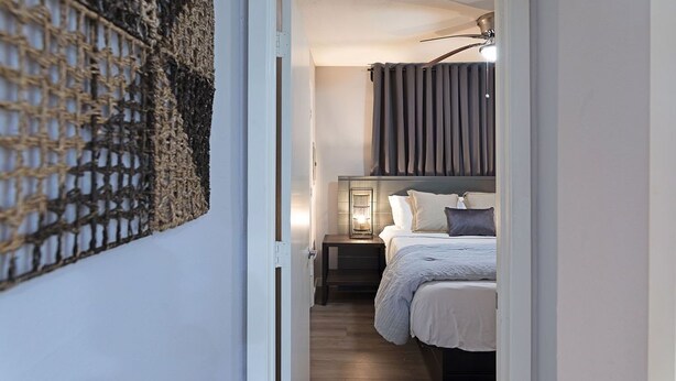 Une chambre à coucher avec un lit, une table de chevet et un luminaire fixé au mur.