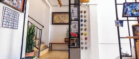 A staircase with a metal railing, a potted plant, and a wall with various signs and decorations.
