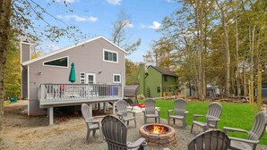 A cabin with a deck, outdoor seating, and a fire pit. - Modern Poconos Central Cozy 5BR Home - Game Room (Tobyhanna)