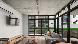 A modern living room with a sofa, coffee table, and TV. - Rambla @ Solarino House (Brunswick)