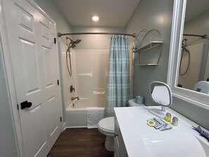 Un baño con ducha, inodoro y lavamanos.